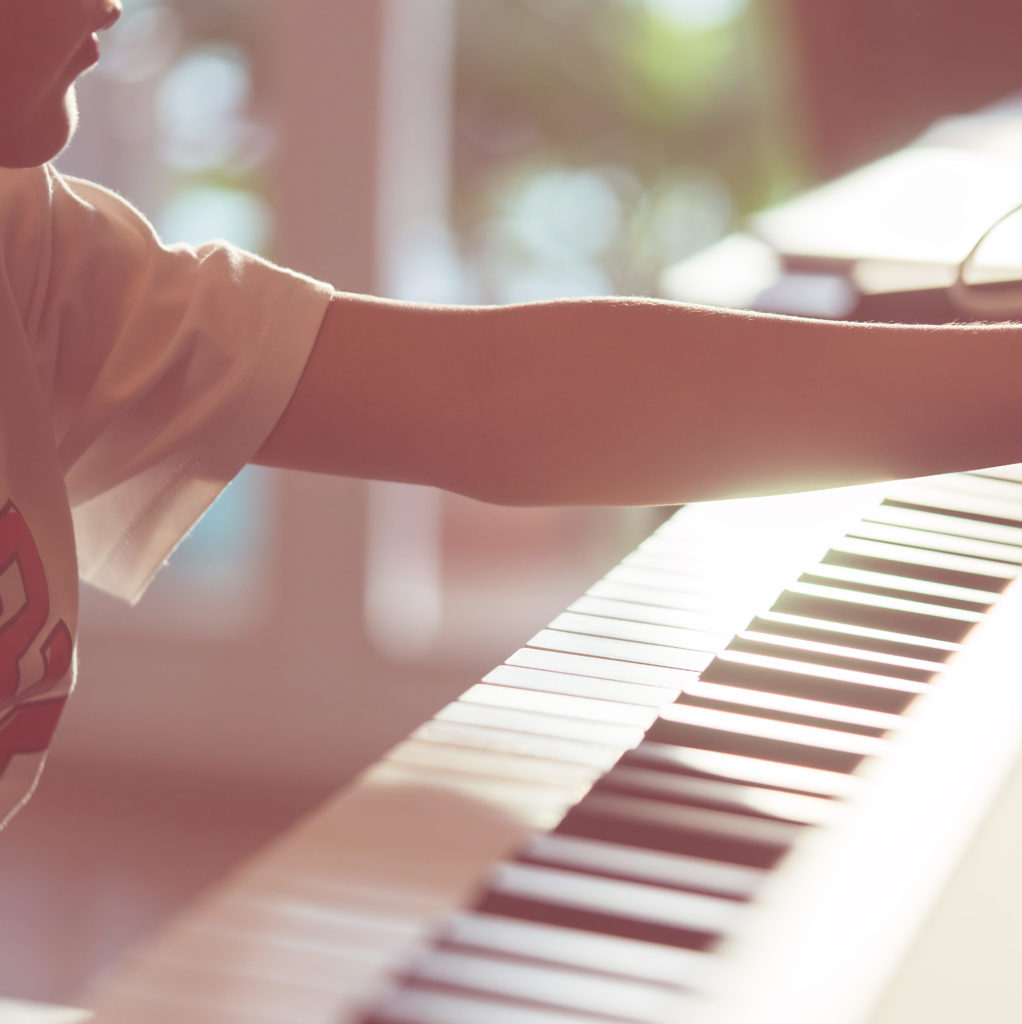 young student preparing to play piano at music lessons